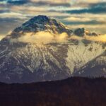 vista panoramica di una montagna innevata al tramonto.